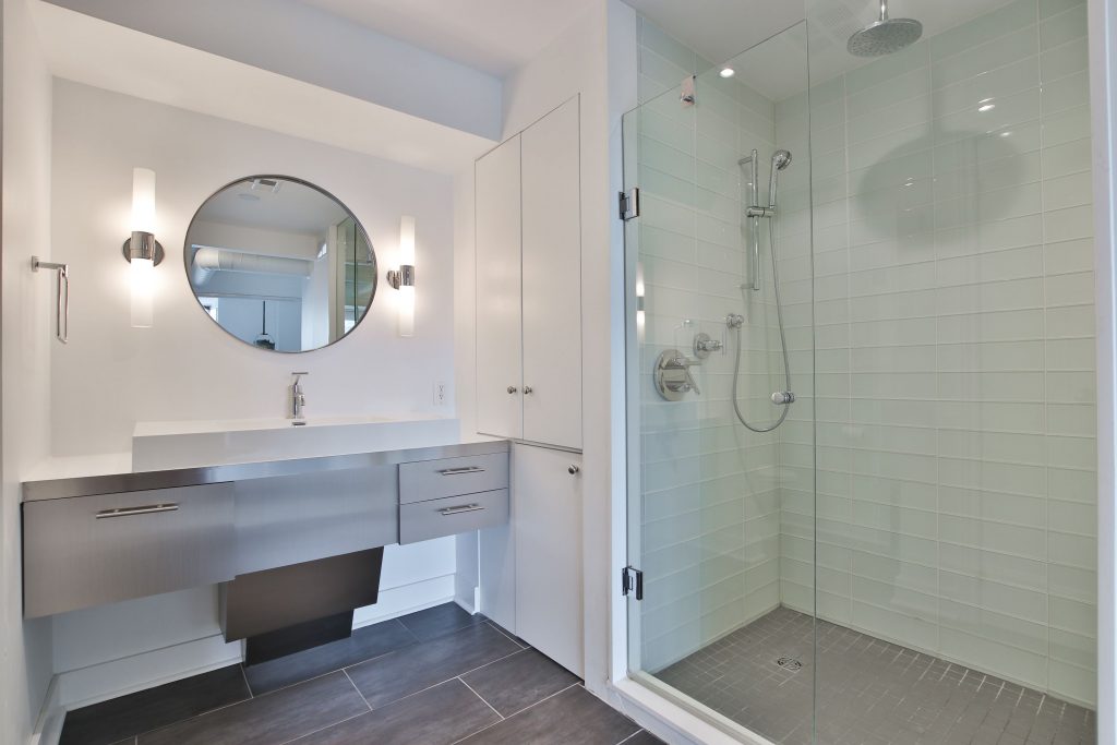 small bathroom with walk in shower and wall mirror - bathroom renovation condo